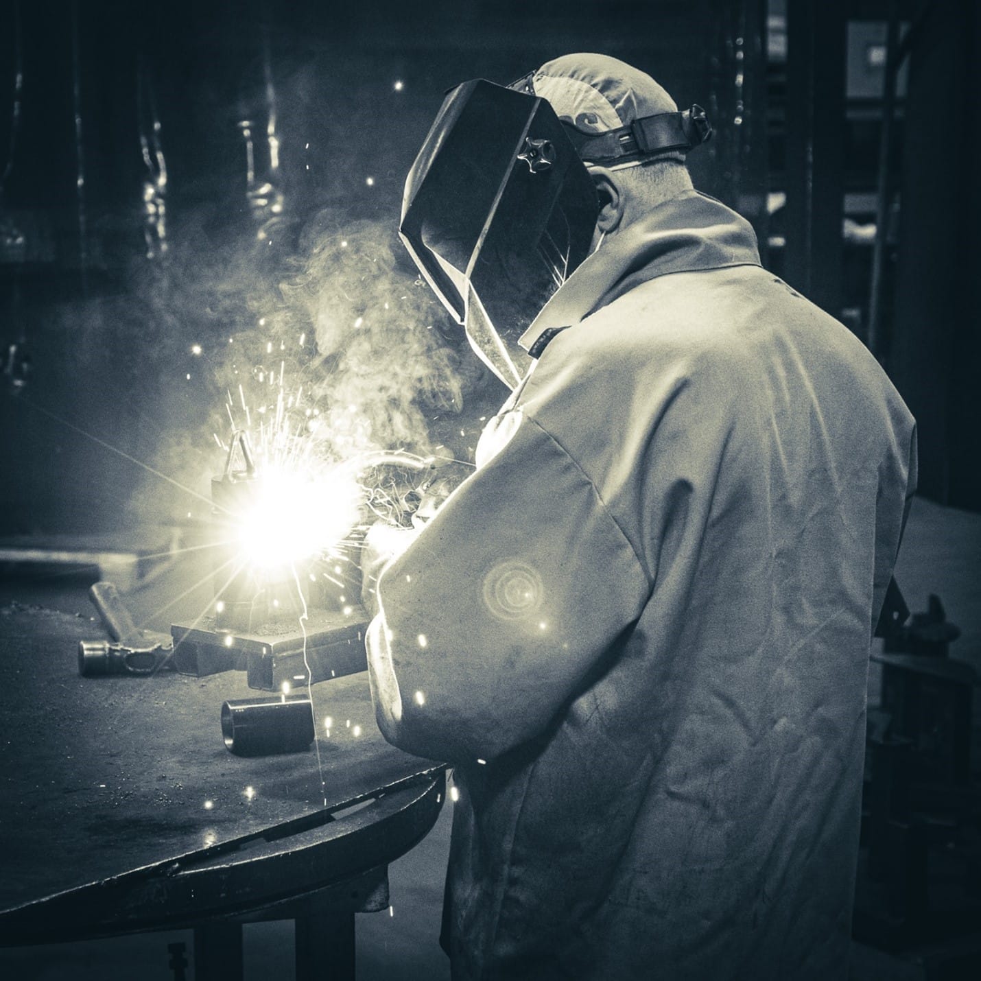Man welding with welding mask and apron on